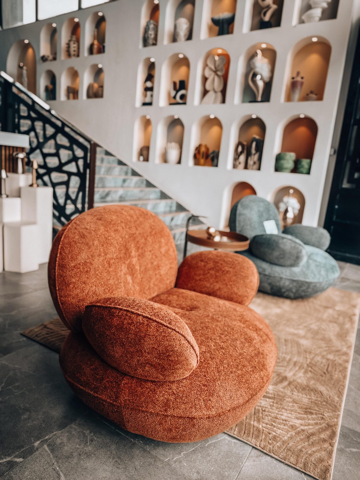 Showroom Doma — mur d'arches et fauteuil terracotta